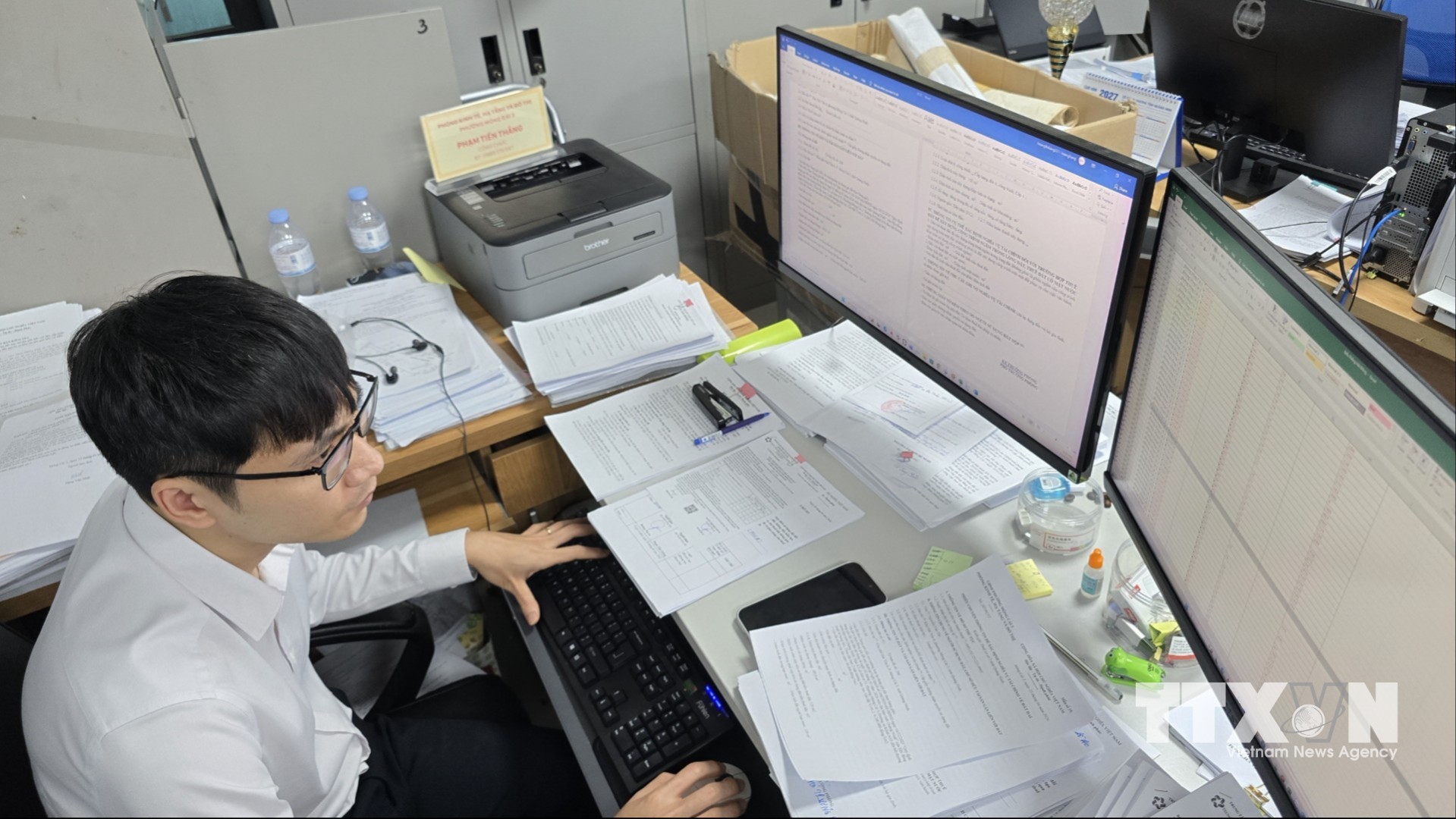Công chức phường Móng Cái 3 thực hiện song song nhiệm vụ giải quyết TTHC trên cổng dịch vụ công và rà soát dữ liệu đất đai. (Ảnh: Thanh Vân/TTXVN)